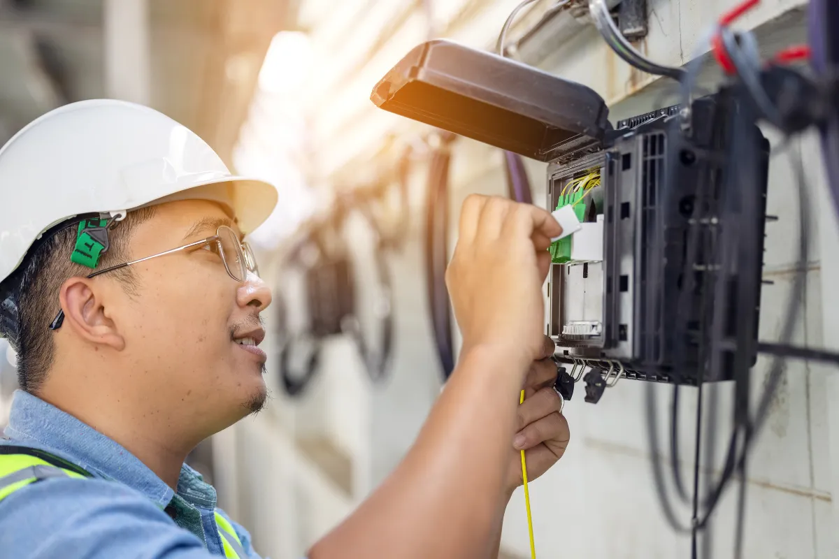 Technician carefully terminating network cables into a patch panel.