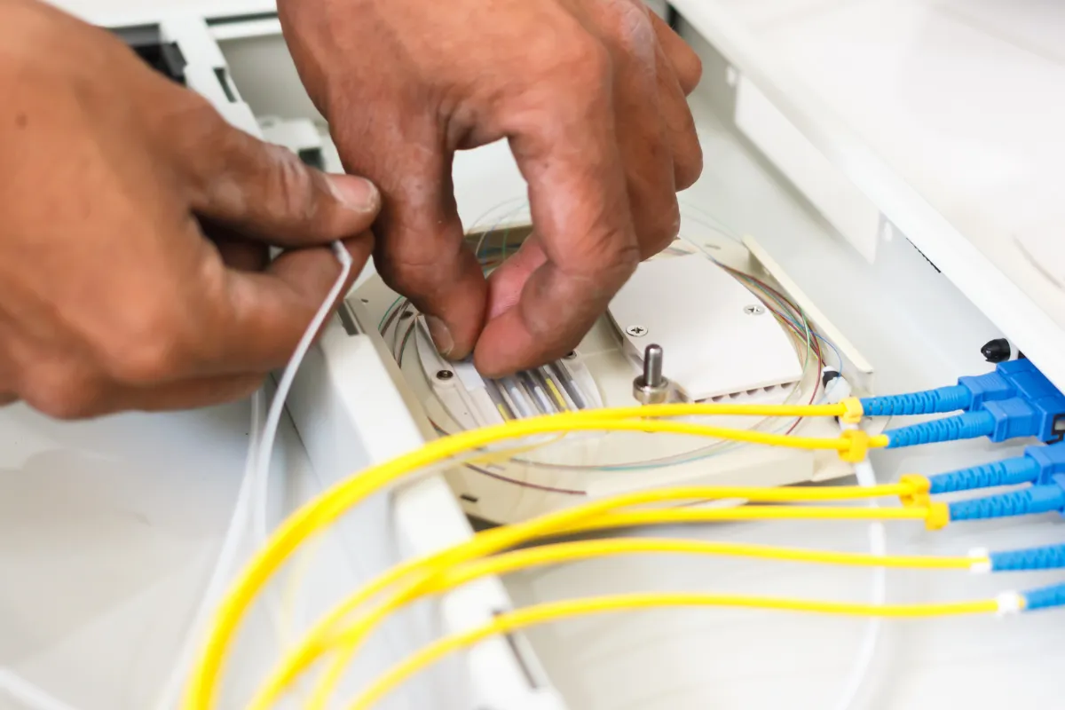 Technician performing precision fusion splicing on fibre optic cables.